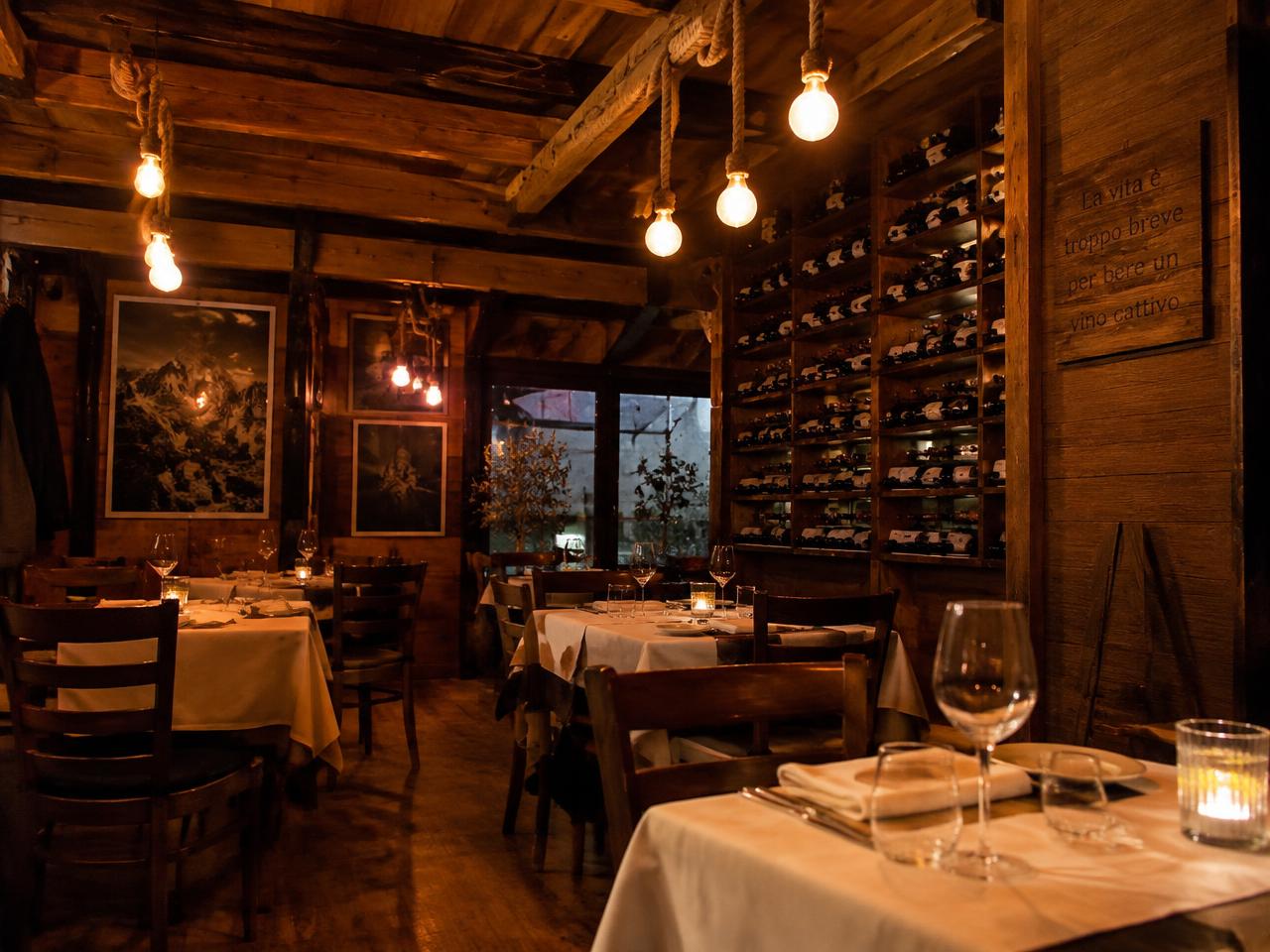 Sala rustica con lampade in corda e parete di vini
